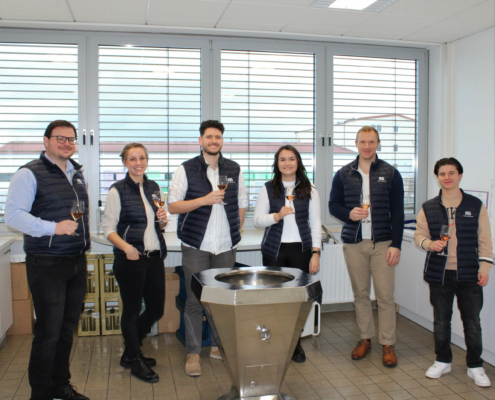 Gruppe lächelnder junger Menschen mit Weingläsern in der Hand